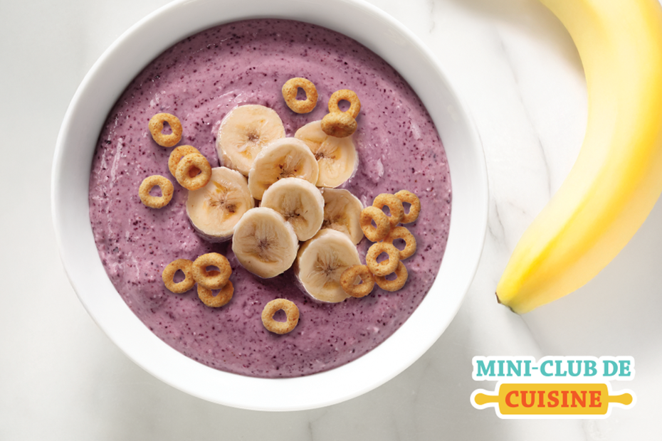 bol smoothie aux bleuets et à la banane avec céréales en forme de O sur le dessus