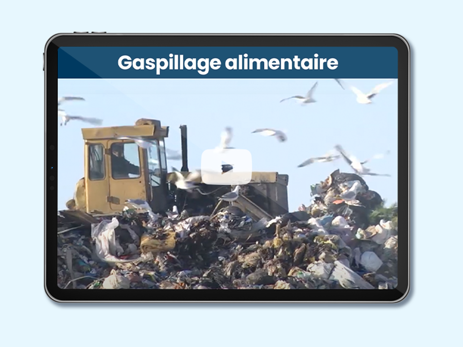 Machine qui pousse des ordures dans une usine de gestion des déchets. Texte sur l'image: Gaspillage et récupération alimentaires