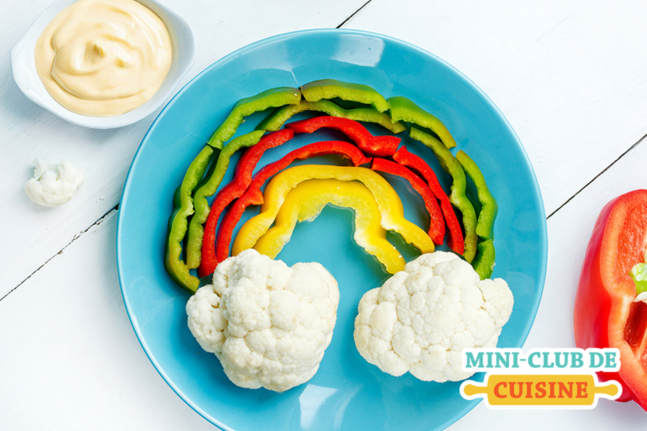 arc-en-ciel fait de poivrons colorés et de chou-fleur comme nuage avec une trempette dans un plat en forme de coeur