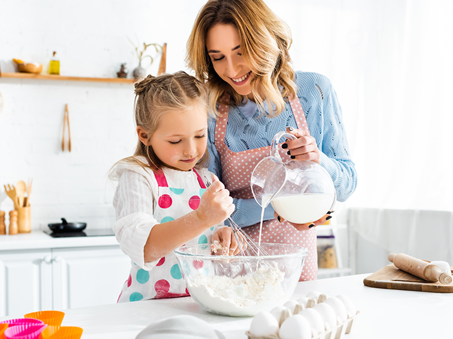 Une adulte qui cuisine avec une petite fille